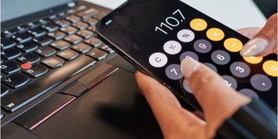 Person using a calculator app on a smartphone in a photo illustration