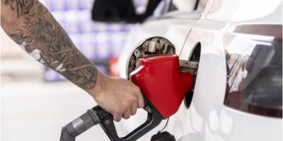 A person pumps gasoline into a vehicle at a gas station in Montreal