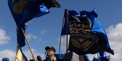 Supporters hold Alberta flags as separation petition organizer Mitch Sylvestre submits signatures to Elections Alberta in Edmonton.