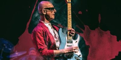 Canadian rocker Kim Mitchell performing live on stage during a concert appearance.