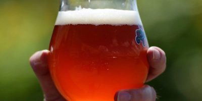 A glass of beer being poured at a bar.