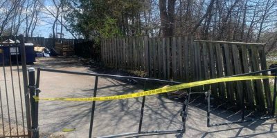 Yellow police tape blocking off an area near the entrance to the Mill Creek townhouse complex on Yonge Street in Barrie