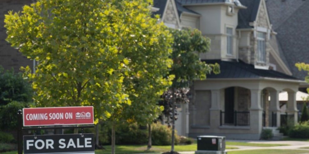 Real estate sign displayed outside homes in Vaughan, Ontario, amid rising housing affordability concerns for younger Canadians.