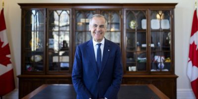 Prime Minister Mark Carney seated in his office in Ottawa, speaking about Canada-U.S. trade relations and energy policy.