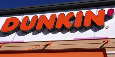 Dunkin’ storefront sign on a café location in Derry, New Hampshire, showing the brand logo above the entrance of a coffee and doughnut shop.