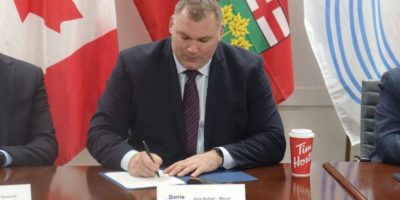 Barrie Mayor Alex Nuttall signs a strong mayor order at Barrie City Hall during a November 2025 news conference.