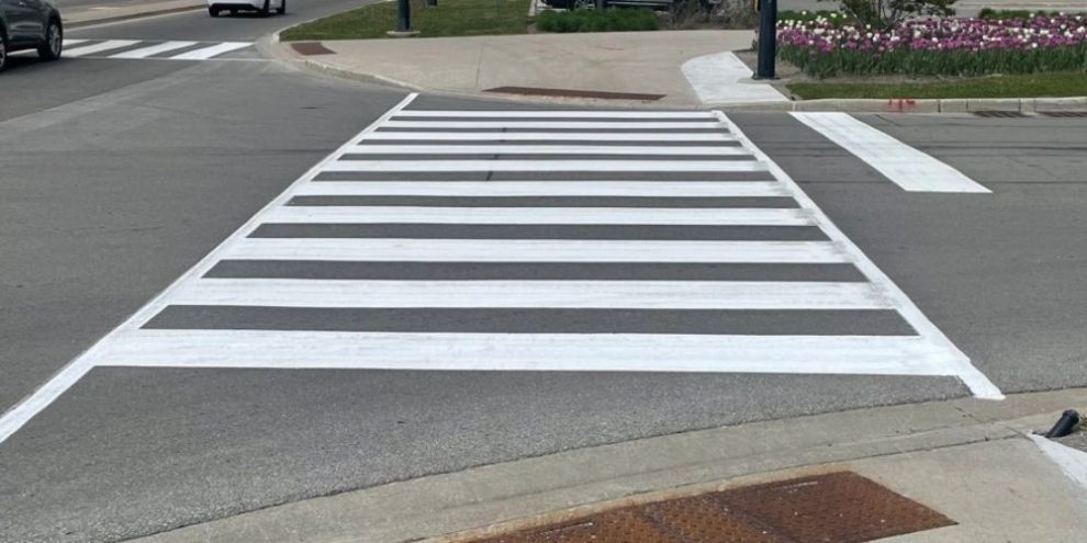 Road crew repainting lane markings and arrows on a Barrie street during overnight maintenance work
