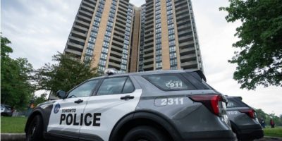Investigators gather outside an apartment building on Martha Eaton Way in Toronto after a police officer was shot during an exchange of gunfire while officers executed a search warrant.