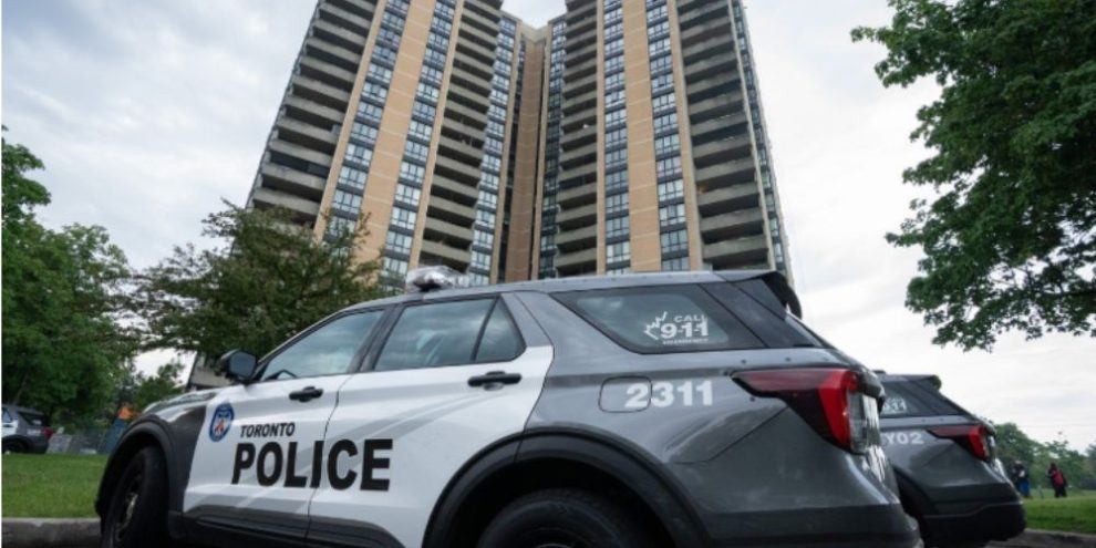 Investigators gather outside an apartment building on Martha Eaton Way in Toronto after a police officer was shot during an exchange of gunfire while officers executed a search warrant.