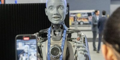 People photograph an AI-powered robot at the All In artificial intelligence conference in Montreal as Canada unveils a new federal strategy focused on AI adoption, trust and innovation.