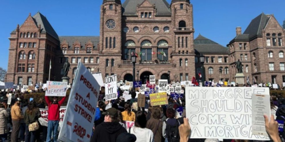 Protesters hold signs at a rally against OSAP cuts outside Queen’s Park in Toronto during March 2026 demonstration.