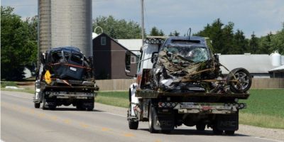 Tow trucks remove wrecked vehicles from the scene of a fatal two-vehicle collision in Mapleton Township, Ontario, where five children were killed.