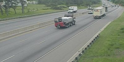 Highway 400 northbound traffic camera view near 11th Line in Innisfil, Ontario, showing vehicles travelling along the highway