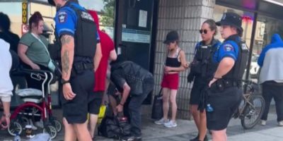 Barrie Police Special Constables stand outside a downtown storefront