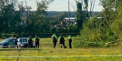 Barrie Police officers stand in an open field near Tiffin Street and Anne Street South in Barrie after skeletal remains were discovered.