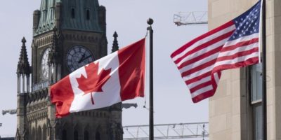 Canadian and United States flags flying near Parliament Hill in Ottawa