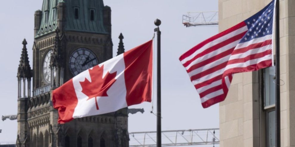 Canadian and United States flags flying near Parliament Hill in Ottawa