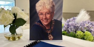 Photo of former Barrie Mayor Janice Laking beside a Book of Condolence