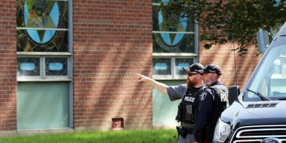 Police stand outside the Sons of Jacob synagogue in Belleville after a shooting