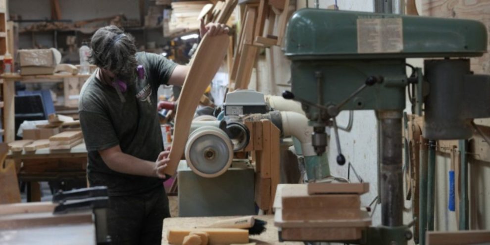 Worker sands an Adirondack chair at a furniture factory in Kemptville, Ontario