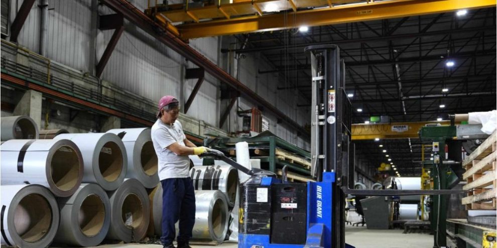 Worker operates a forklift near steel coils at a manufacturing plant in Ottawa.
