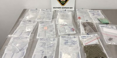 Southern Georgian Bay OPP display suspected drugs and other items seized from a vehicle in Midland.