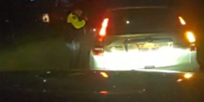 Barrie Police officer shines a flashlight into the vehicle involved in an impaired driving investigation.
