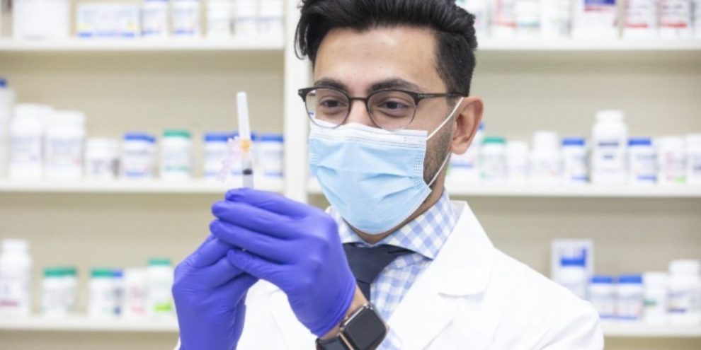 Pharmacist Mina Iskander prepares to administer a flu shot at a Toronto pharmacy on Nov. 18, 2021.