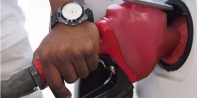 A person pumps gasoline at a Toronto gas station as fuel prices rise.