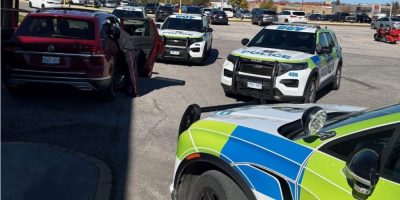 Barrie Police cruisers surround a stolen SUV in a Bayfield Street parking lot in Barrie on Oct. 18, 2026.