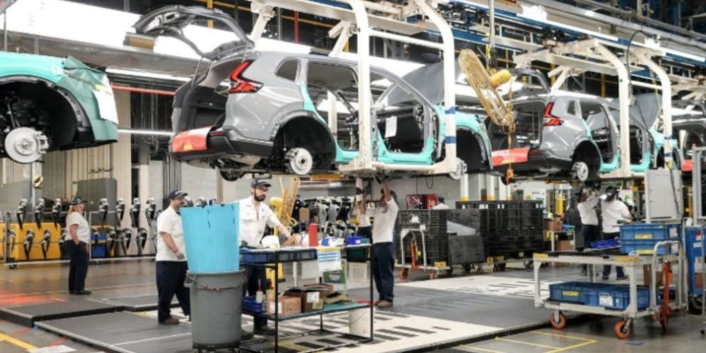 Honda employees work along the vehicle assembly line in Alliston, Ontario, on April 25, 2024.