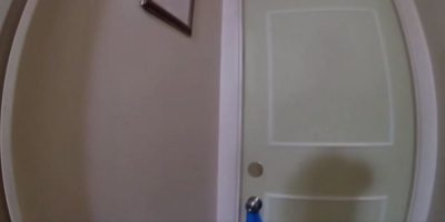 Screenshot of a Barrie Police officer kicking open a door to rescue cats locked in a room.